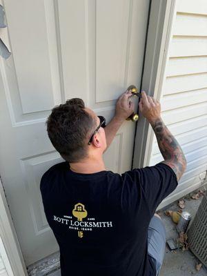 Bott locksmith opening a deadbolt lock on the side of a customers home