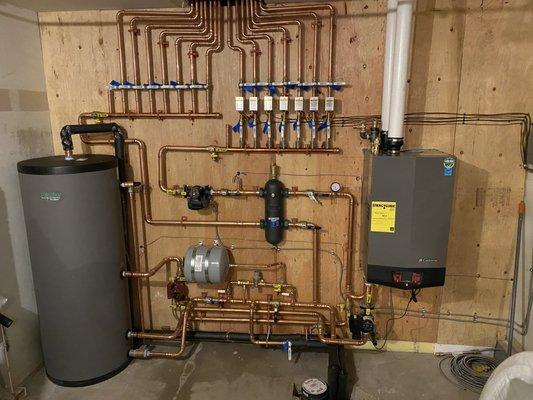 Installation of a boiler, boiler side arm, and radiant floor heating.