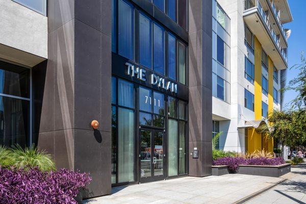 Exterior of building facing the front doors to the community with a sign that reads The Dylan.