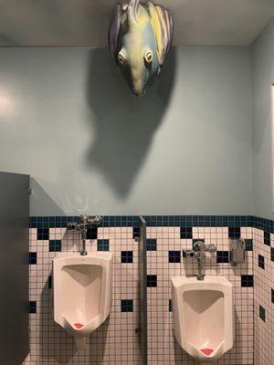 Fish staring directly at you from above the bathroom urinal.