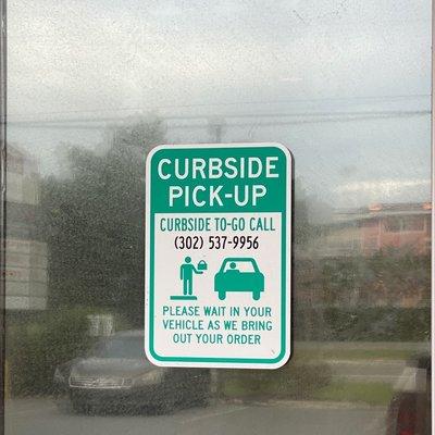 Curbside pick up sign with phone number