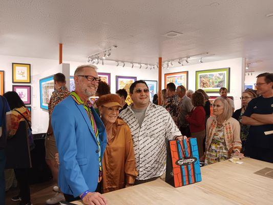 Josh Agle posing with customers at a print release party