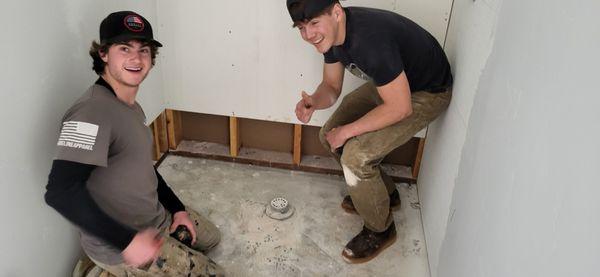 Colton , chase setting up a shower curb and shower pan. These guys are the greatest.