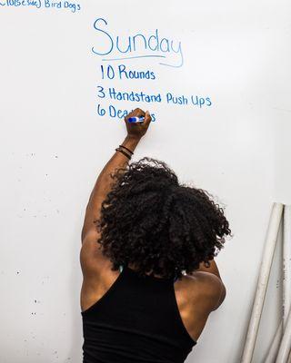 Coach Mo writing up the workout of the day