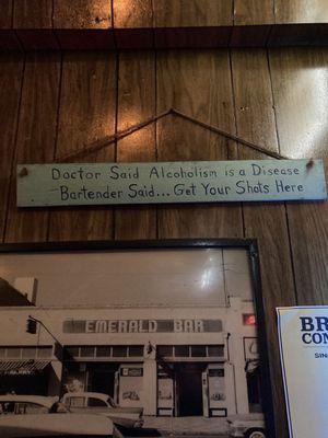 Sign in the bar along with old photo of the bar.