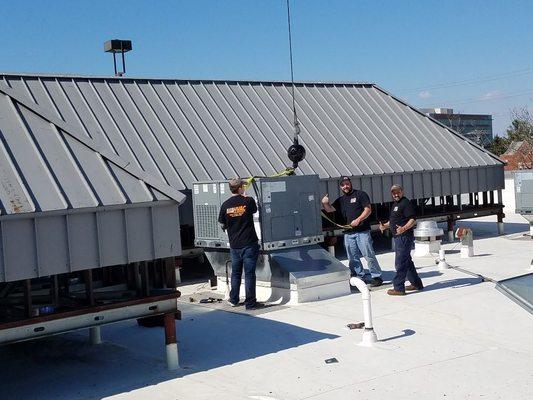 Technicians setting a roof top unit