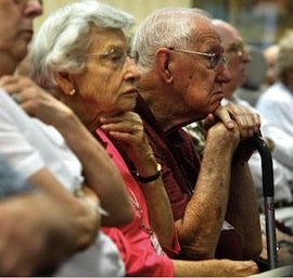 Seniors listening to information at a senior health conference.