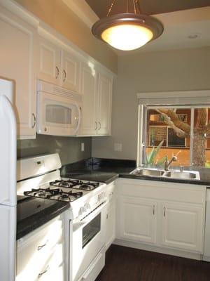 Kitchen area of  the one bedroom, downstairs unit with upgrades. All units have bay windows, refrigerators, dishwashers, & microwaves.