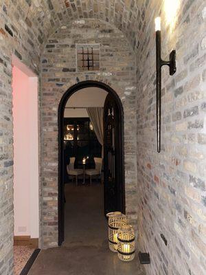 View looking down the hall from the entrance and into the main chamber of the speakeasy