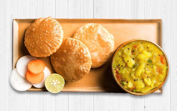 Tasty Indian deep-fried soft & puffy bread with warm and lightly spiced aloo sabji or bhaji with hints of coriander, ginger and other Indian