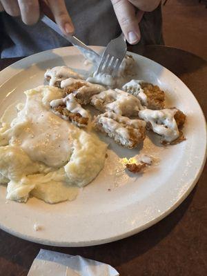 Boneless pork chop special with mash potatoes gravy and a side salad.