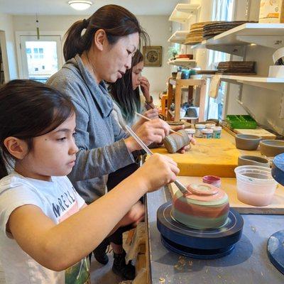 Students glaze their work in a private class.