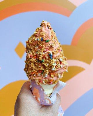 Our twist soft serve dipped in strawberry passionfruit dip and rolled in our rainbow peanut crunch!