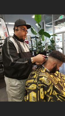 Frank, owner giving a fade haircut service