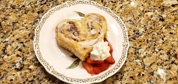 Tender heart shaped cinnamon roll with buttery filling and cream cheese topping to celebrate Valentine's day.