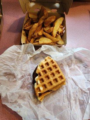 Sausage and waffle sandwich with large potatoes.