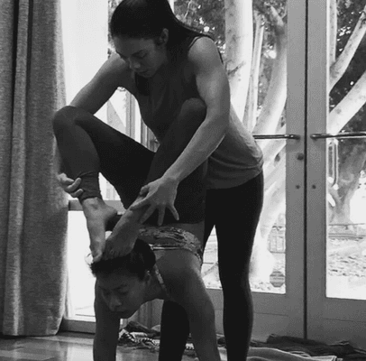 Krista adjusting a student in a more challenging yoga posture