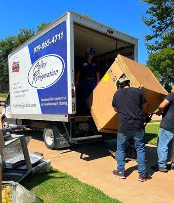 Install crew unloading a new HVAC system to be installed