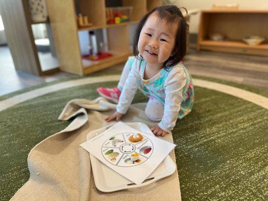 Toddler grasping the concept of Montessori floor work