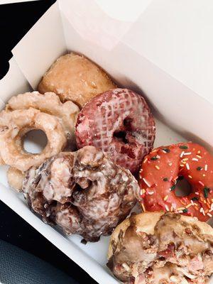 Sour Cream Donut, Raspberry Filled (I think), peach fritter, red velvet, maple bacon, strawberry w/sprinkles