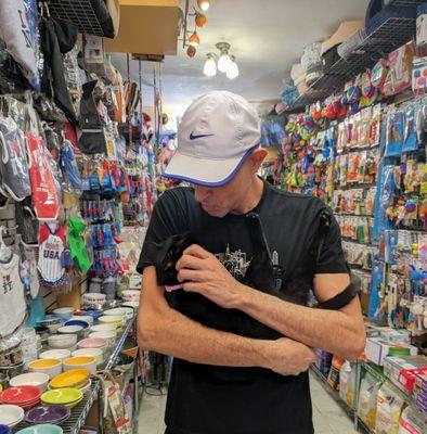 The owner Eddie and his rescued shop cat Chloe in the store amid a vast selection of cat bowls, dog treats, toys, and many many products.