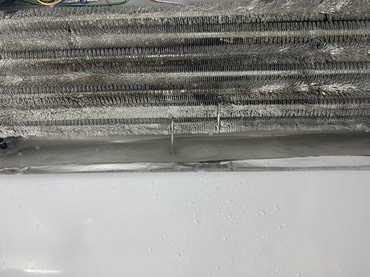 Not cleaning condenser coils makes refrigerator work hard and leads to defrost drain blockage causing ice buildup in freezer