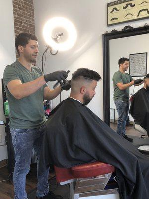 Edgar working on a bald fade.