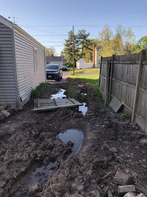 Side by our garage where they used our fence to walk on and also the side of garage that they hit with their machinery.