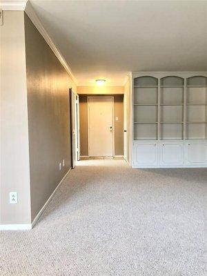 Entryway.  Living room with no furniture.  Empty shelves.