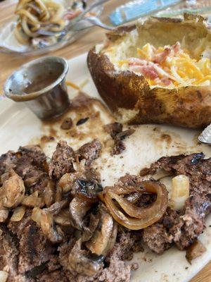 Hamburger steak with grilled onions and mushrooms and baked potato.