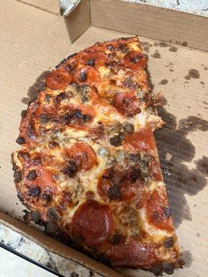 This is a greasy look of burnt pizza.