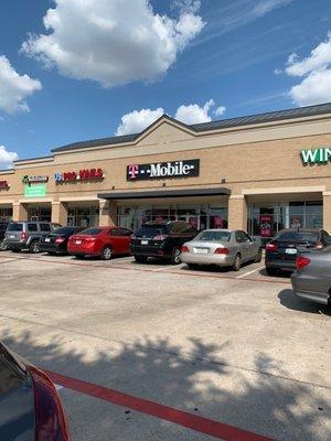 T-mobile is located in a small shopping center between Wingstop and a nail shop.