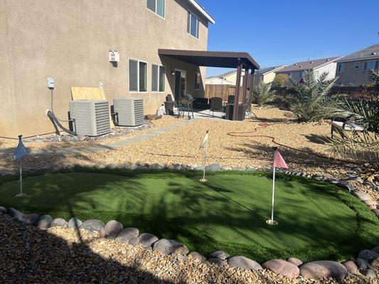 Back yard desertscape installation with concrete slab and patio cover