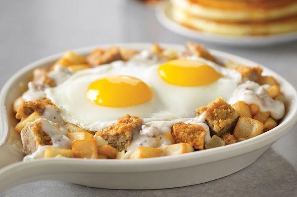 Chicken-Fried Steak Breakfast Skillet, country potatoes topped with 2 eggs and chicken-fried steak and onions in our country sausage gravy