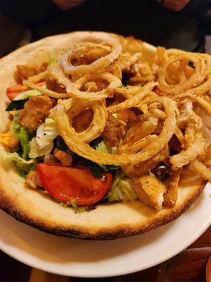 Large salad with fried onion rings.