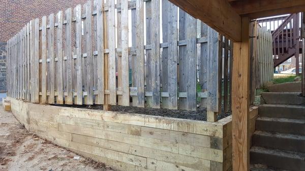 WE ATTACHED THE FENCE TO THE RETAINING WALL.  MUCH STRONGER.