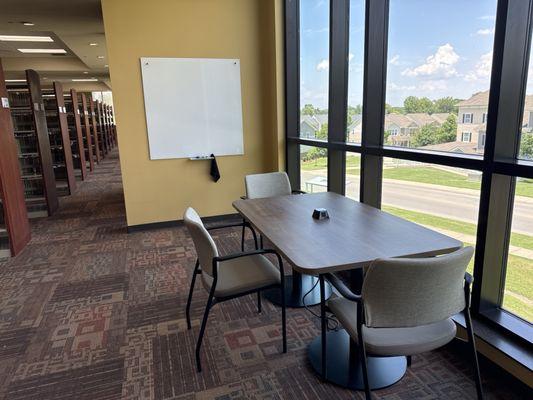 White board and Table and chairs along window on second floor