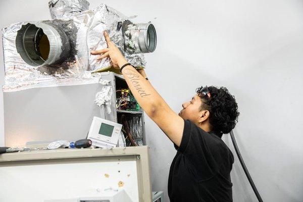 HVAC student working on unit.