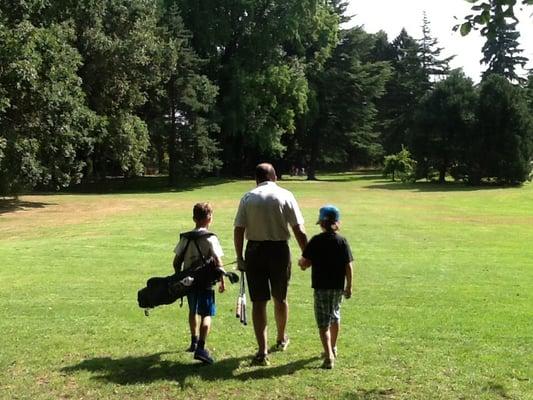 Papa Peter in the middle, with Levi on the left packin the clubs,and Milo on the right, strolling down the fairways at Greenlake