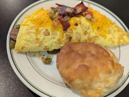 Omelette with bacon, onion, peppers, and cheddar cheese with a biscuit.