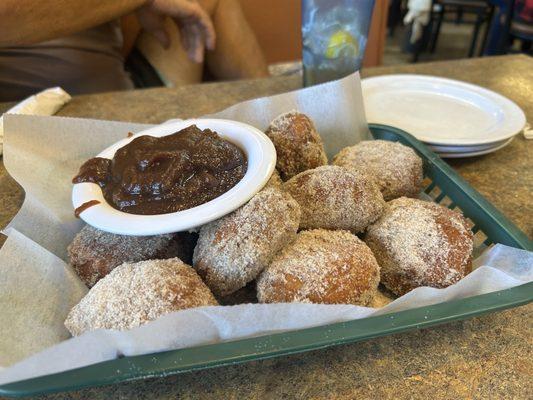 Fried biscuits dusted with cinnamon sugar with a side of sweet apple butter.