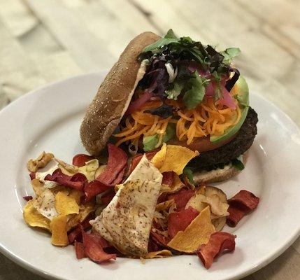 Bangin' Black Bean Burger - A black bean burger with tomato, avocado, baby greens, bistro sauce, and pickled onions and carrots on a bun