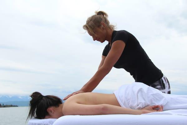 Heather Reddig owner of Aqua Marine Massage performs massage therapy for her clients from the deck if a pontoon boat.