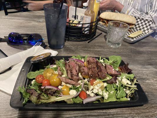 Grilled steak salad with a super fresh salad mix and ripe tomatoes.