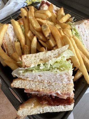 Turkey club with provolone and fries on the side. Delicious