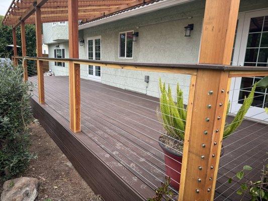 Composite deck with wire rails and wooden pergola