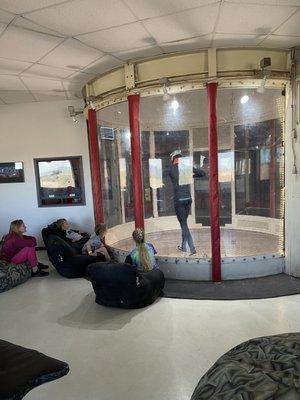 Inside of facility for the indoor skydiving. Waiting area viewing person inside