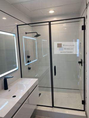 Inline frameless shower door enclosure with custom black matte frame and hardware