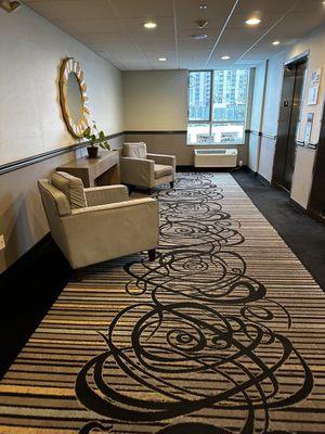 The area in front of the elevator on the room floor. Nice area to read a book with some natural lighting