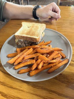 Ribeye steak sandwich (delicious) with sweet potato fries.